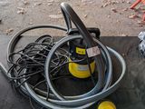 une photo montrant un tuyau et d'autres équipements électriques posés au sol