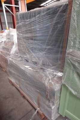 un canapé emballé dans du plastique et posé sur une palette