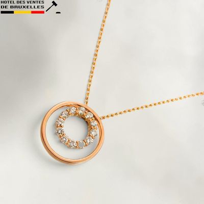 a gold plated necklace with a circle pendant and a diamond set in the center