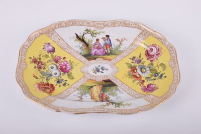 une assiette jaune sur laquelle sont représentés une femme et un oiseau