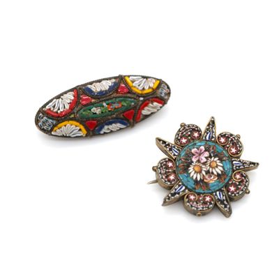 two small brooches with colorful designs on them sitting next to each other