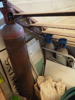 un extincteur posé au sommet d'un tas de vieilleries