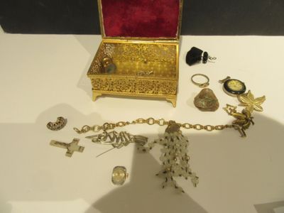 un coffret à bijoux en or posé sur une table, à côté d'autres objets