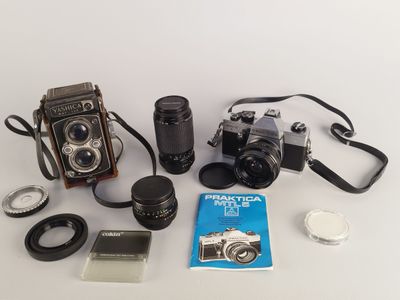 un appareil photo, un objectif, un étui pour appareil photo et un livre posés sur une table