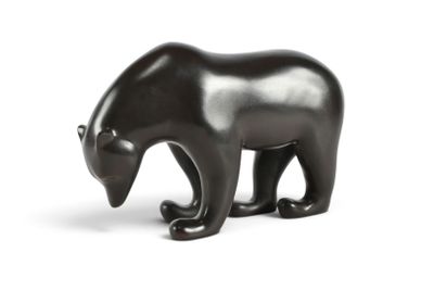 une figurine d'ours noir posée sur une surface blanche