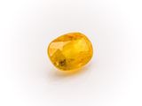 a yellow sapphire stone on a white background