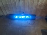 une enseigne lumineuse sur laquelle est inscrit « ce sor 21h »