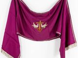 a close up of a purple shawl with a cross and two doves on it
