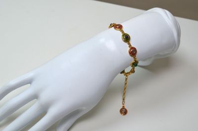 Un bracelet en argent vermeil, décoré d'émail rouge et vert,…