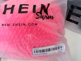 a pink ball of yarn in a bag on a table