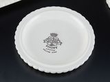 a white plate with a crown on it sitting on a table
