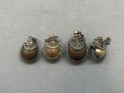 three antique silver and gold brooches on a gray surface