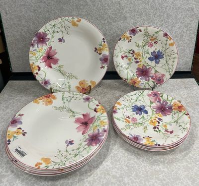 trois assiettes ornées de fleurs, posées sur une table