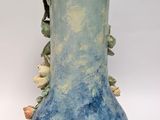 a blue vase with flowers on it on a white surface