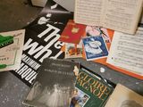 several books are sitting on a table next to an open book