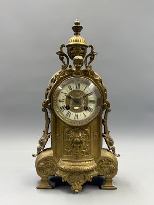 a gold clock sitting on top of a table