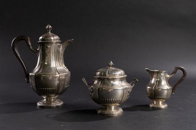 trois théières en argent et une cafetière posées sur une table