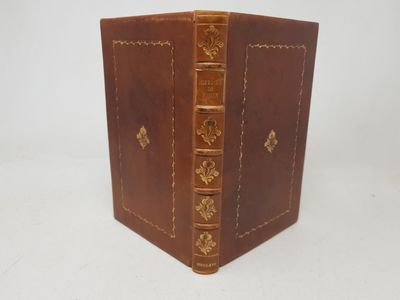 an old leather book with gold trimming on the cover