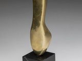 a bronze sculpture of a foot on a black marble base