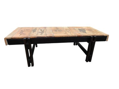 La table est en bois et possède des pieds en métal