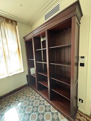 une grande bibliothèque en bois dans un coin de la pièce