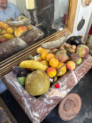 a man standing in front of a mirror with a tray of fruit on it