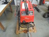 a red machine that is sitting on top of a pallet