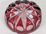 a red glass bowl with a white label on it