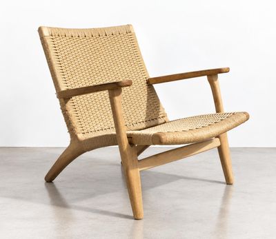 the chair is made of wood and has a woven seat
