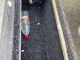a bottle of soda sitting in the middle of the floor