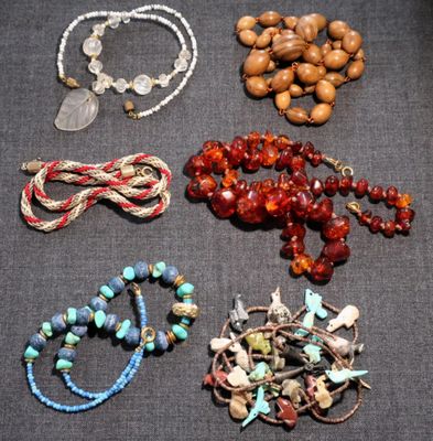 plusieurs types de perles et de colliers posés sur une table