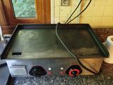 a stove top with two burners on it in a kitchen
