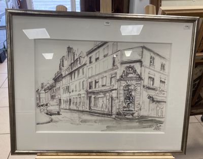 drawing of a building in a frame on a table in front of a window