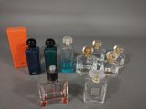 plusieurs flacons de parfum posés sur une table, à côté d'une boîte orange