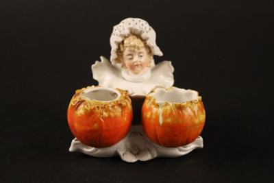 une figurine représentant une femme tenant deux pommes