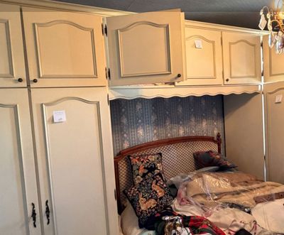 un lit dans une chambre où se trouve un lustre, avec un autre lustre au-dessus
