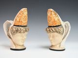 une paire de figurines en céramique représentant un homme et une femme coiffés de chapeaux