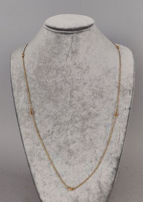a white mannequin with a gold chain on it