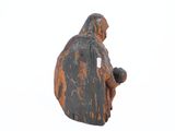 an old statue of a man holding a baby in his arms