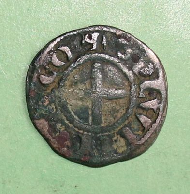 a close up of an old coin on a green surface