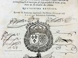 un vieux livre sur lequel figurent des armoiries et une couronne