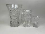 trois vases en verre posés l'un à côté de l'autre sur une table
