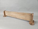 a small wooden bench with a metal holder on it