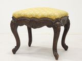 an old wooden bench with yellow and white fabric on it