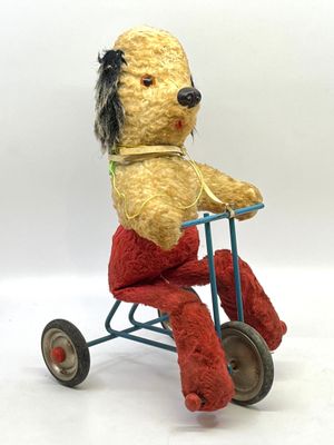 Chien mécanique à tracter en peluche pédalant sur son tricyc…