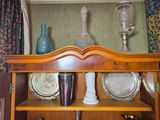 a wooden cabinet with plates and vases on top of it
