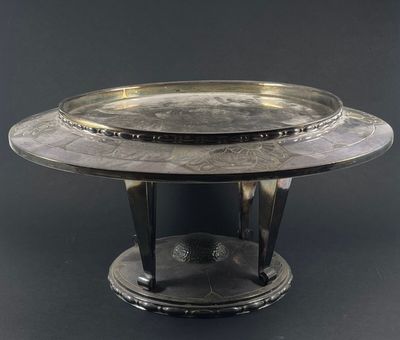 an image of a silver plate on a stand on a black background