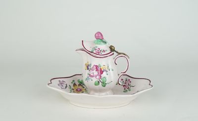 une petite théière et une soucoupe posées sur une table blanche