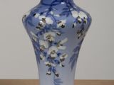 un vase bleu orné de fleurs blanches, posé sur une table
