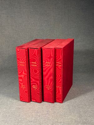 three red books sitting on top of each other on a table